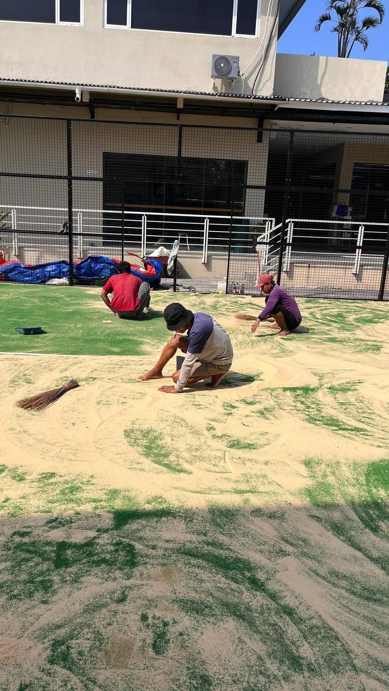 Tim PadelTurf spread pasir silica di lapangan outdoor
