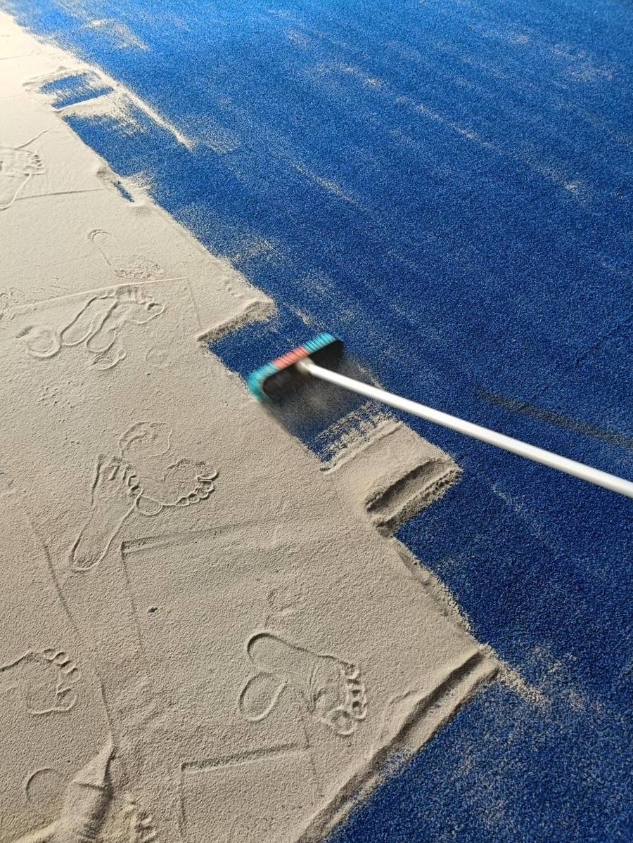 Detail brushing pasir silica di karpet biru